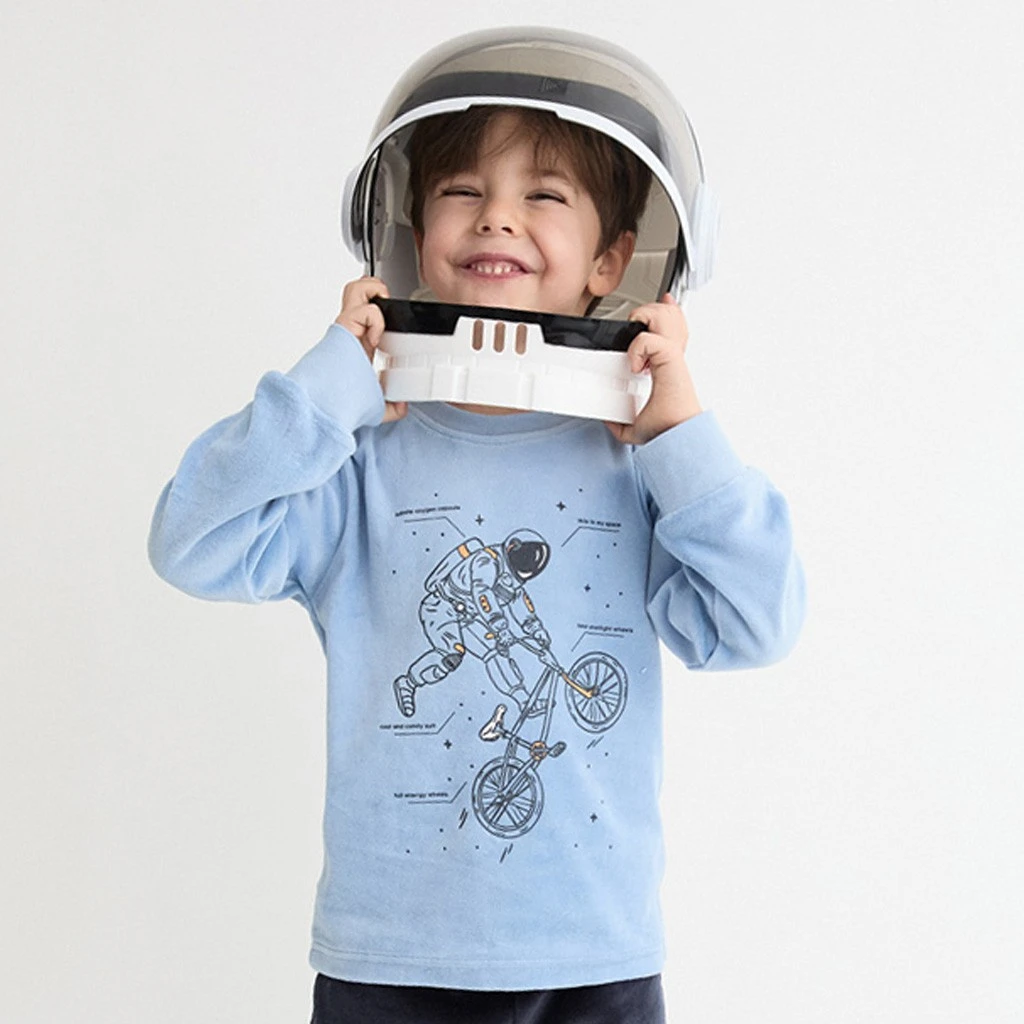 Camiseta azul claro del pijama infantil con dibujo de astronauta sobre una bicicleta